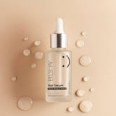 BLS-HV hair serum bottle on a beige background with droplets